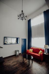 恩塞纳达港Trojan House的客厅配有红色沙发和蓝色窗帘