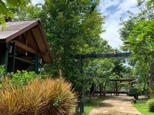 安帕瓦农尼邦康提度假村的一个带木制凉棚和树木的花园