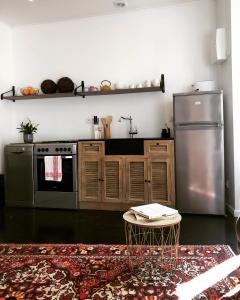 雅尔纳克Studio du Cherche Midi的厨房配有不锈钢冰箱和桌子