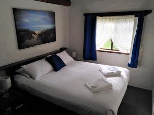 巴瑟尔顿沙湾假日公园酒店的一间卧室配有白色的床、蓝色窗帘和窗户