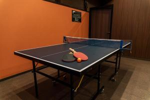 奈良樱花酒店 的乒乓球桌和两把网球拍
