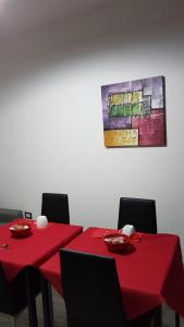 SestuDomos Loru的两张红色的桌子和椅子,墙上挂着一幅画