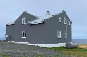 Grímsey博萨旅馆的前面有桶的大灰色房子