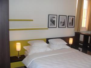 斯韦蒂·斯特凡Apartments Danilo Kažanegra的一间卧室配有一张带两盏灯的床,墙上挂有图片