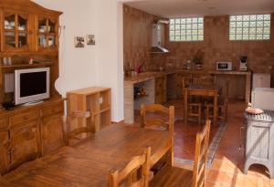 Los TeatinosCasa Rural Rosa Blanca的厨房配有木桌和电视。