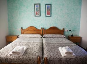 Los TeatinosCasa Rural Rosa Blanca的一间卧室配有一张床,上面有两条毛巾
