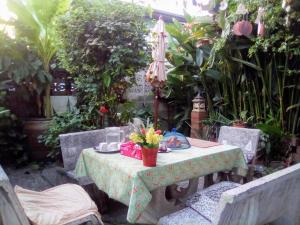 班敦孟Ban Kru Ae mixed dorm的花园里种有植物,配有桌椅