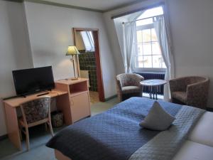霍瓦赫特霍赫瓦赫特霍夫旅馆的一间卧室配有一张床、一台电视和一张书桌