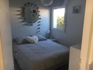 基伯龙Appartement T2 refait à neuf, piscine的卧室配有一张壁挂镜子的床