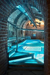 克拉科夫哥白尼酒店的砖砌建筑中带蓝色灯光的室内游泳池