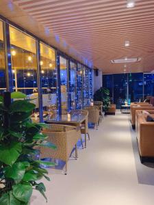 Long KhanhQuốc Thanh Hotel的餐厅设有桌椅和窗户。