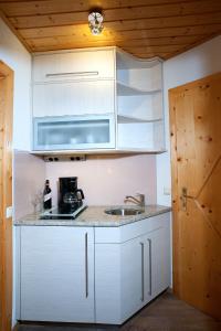 OberaichwaldGästehaus Elisabeth的厨房配有白色橱柜和水槽