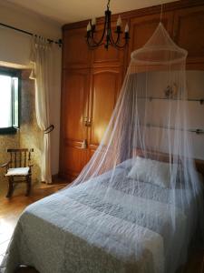 VimianzoCASA O QUINTEIRO的一间卧室配有一张带蚊帐的床