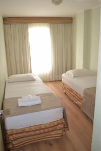 库里提巴安姆皮萨酒店的酒店客房设有两张床和窗户。
