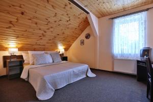 PerninkTradice (U Bendů)的一间卧室设有一张大床和木制天花板