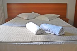 库里提巴安姆皮萨酒店的一张带两条毛巾和两个枕头的床
