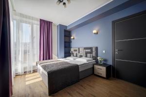 特维尔Hotel Luidor的一间卧室配有一张蓝色墙壁的床和一扇窗户