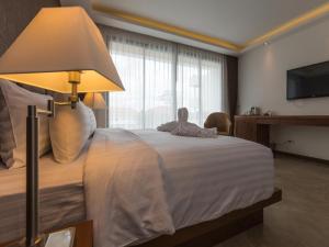 拉威海滩行动点减肥健身度假酒店的一间卧室配有一张带灯具的床和一台电视