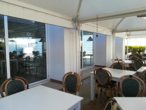 阿利米尼Residence Serra Alimini 1的用餐室设有桌椅和窗户。
