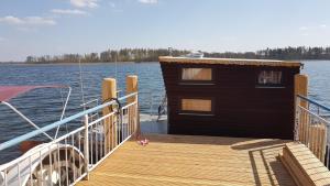 滨湖克拉科Hausboot Krakow am See Forelle 1 und 2的水面上一座小建筑的木头码头