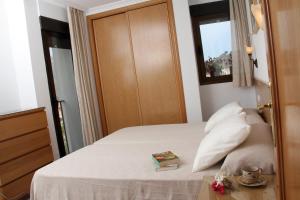 贝尼曼特利APARTAMENTOS SERRELLA - Rural Guadalest的一间卧室,配有一张床铺,桌子上放着一本书