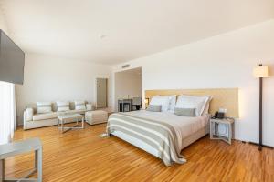 Montes de CimaAlgarve Race Resort - Hotel的白色卧室设有一张大床和一张沙发