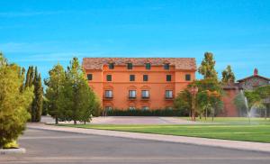 埃莫西约Hotel Boutique Villa Toscana的一座大型的橙色建筑,前面有树木