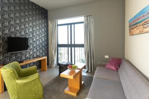 耶路撒冷Hillel 11 Hotel的带沙发和电视的客厅