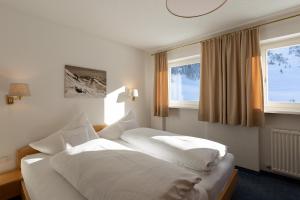 莱赫阿尔贝格Chalet Schneekristall的一间卧室设有两张床和两个窗户。