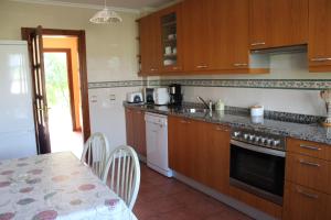 帕阿斯德兰斯埃尔吉迪奥乡村度假屋的厨房配有木制橱柜、桌子和桌子以及用餐室。