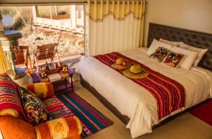 普诺Luz del Titicaca Lodge的一间卧室配有一张大床,上面有两顶帽子