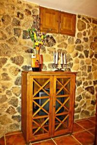 Casas del CastañarCASA RURAL LA CABRERA的木柜,石墙顶上有一个花瓶