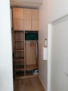 迪纳尔Studio Winston的衣柜配有木制橱柜和冰箱