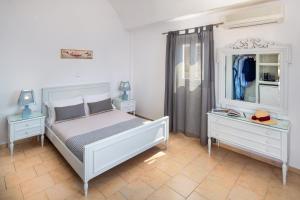 阿克罗蒂里阿克罗蒂里酒店的一间卧室配有床、两个梳妆台和镜子