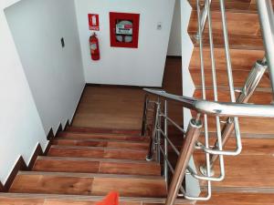 库斯科Real House Cusco的楼梯,铺有木地板,配有灭火器