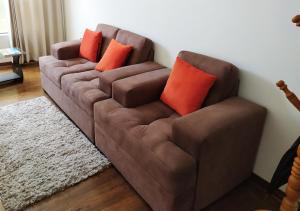 库斯科Real House Cusco的客厅里配有带橙色枕头的棕色沙发