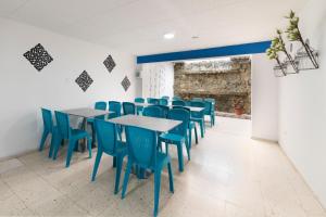 波哥大Ayenda 1055 Agora INN Corferias的一间配备有蓝色椅子和桌子的用餐室