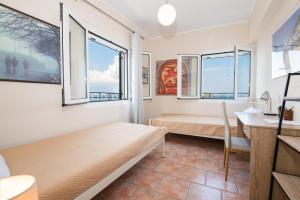 科孚镇City walls sea view的卧室配有一张床、一张书桌和窗户。