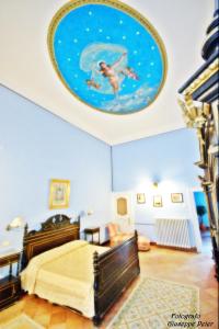 卢切拉B&B Casa Cavalli的一间卧室配有一张床,天花板上画着一幅画
