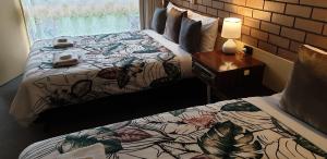 Millicent矶鹬汽车旅馆@米利森特的一间卧室配有两张床和一张带台灯的桌子