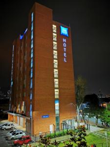 麦德林ibis budget Itagui的夜间标有标志的酒店大楼
