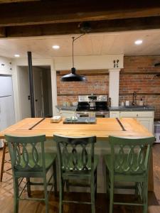 Stafford SpringsInnkeeper's Place B&B的厨房配有带绿色椅子的大木桌