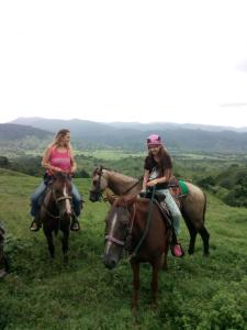 Puerto LindoHostel Wunderbar的两个女孩在田间骑马
