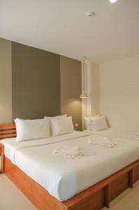 甲米镇甲米皮塔酒店的一张白色大床,配有白色床单和枕头