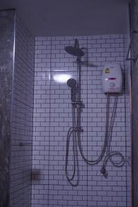 Nang RongS.S.Hotel Nangrong的白色瓷砖浴室设有淋浴和吹风机