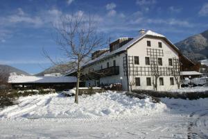 布鲁尼科Appartementhaus Lechnerhof的雪中有一棵树的白色建筑