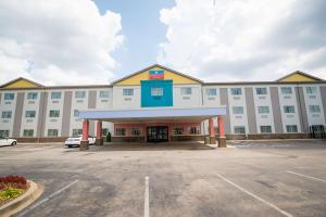 路易斯威尔SureStay Plus by Best Western Louisville Airport Expo的一座大型白色建筑,设有停车场