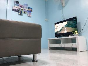 合艾Blue House Hat Yai的一间带电视和沙发的客厅
