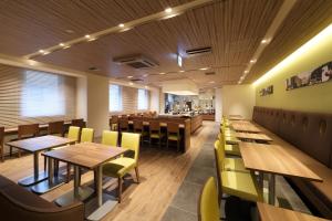东京东京八重洲站京王普雷索经济型酒店的餐厅设有木桌和黄色椅子