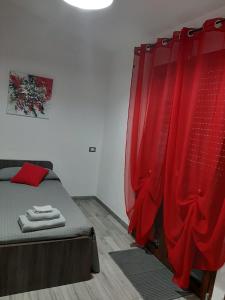 SestuDomos Loru的一间卧室配有一张带红色窗帘的床